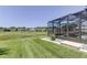 This screened patio overlooks a large green lawn with views of nearby community houses at 8609 Regal Ln, Hudson, FL 34667