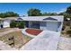 Attractive home with a blue exterior, a well-kept lawn, and a driveway leading to a garage at 8906 Farmington Ln, Port Richey, FL 34668