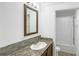 Bathroom featuring single sink, wood-framed mirror, and shower-tub with white shower curtain at 9896 Scepter Ave, Brooksville, FL 34613