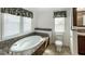 Serene bathroom features a soaking tub with granite surround, enhancing the home's appeal at 9896 Scepter Ave, Brooksville, FL 34613