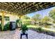 Outdoor space with covered patio, lush landscaping, and tranquil pond views at 9925 Whitworth Ct, New Port Richey, FL 34655