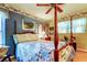 Charming bedroom with a four-poster bed, quilt, and decorative wallpaper border at 9925 Whitworth Ct, New Port Richey, FL 34655