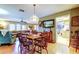 Charming dining room with a wooden table, decorative lighting, and views into the living area and kitchen at 9925 Whitworth Ct, New Port Richey, FL 34655