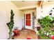 Welcoming front entry with a tiled porch, decorative plants, and a charming, colorful front door at 9925 Whitworth Ct, New Port Richey, FL 34655