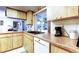 Bright kitchen with wood cabinets, white appliances, and a sunny window over the sink at 9925 Whitworth Ct, New Port Richey, FL 34655