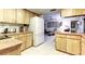 Bright kitchen with wood cabinets and white appliances; open to the living space at 9925 Whitworth Ct, New Port Richey, FL 34655
