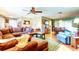 Spacious living room flowing into the dining area, featuring a sectional sofa and wood-look flooring at 9925 Whitworth Ct, New Port Richey, FL 34655