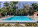Inviting community pool surrounded by mature trees and lounge chairs, perfect for relaxation and recreation at 9925 Whitworth Ct, New Port Richey, FL 34655