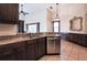 Stylish kitchen featuring granite countertops, stainless steel appliances, and dark wood cabinetry at 10056 Lebanon Dr, Port Charlotte, FL 33981