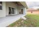 Covered patio with sliding glass doors and ceiling fan overlooking grassy backyard at 10056 Lebanon Dr, Port Charlotte, FL 33981