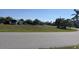 Grassy vacant lot situated on a peaceful residential street with trees at 10056 Lebanon Dr, Port Charlotte, FL 33981