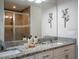 Well-lit bathroom with granite countertop, dual sinks, and modern decorative wall art at 10114 Briar Cir, Hudson, FL 34667