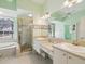 Primary bathroom with dual sinks, tiled floors, soaking tub, and glass shower at 10285 Velvetseed Cir, Spring Hill, FL 34608