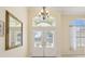 Grand foyer featuring a glass front door, high ceilings, and an arched transom window at 10285 Velvetseed Cir, Spring Hill, FL 34608
