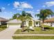 A bright and charming home with a well-manicured lawn and palm trees at 10285 Velvetseed Cir, Spring Hill, FL 34608