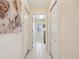 Neutral hallway featuring tile flooring, white doors, and access to the laundry room at 10285 Velvetseed Cir, Spring Hill, FL 34608