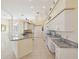 Spacious kitchen boasts a large island with granite countertops, white cabinets, and tile flooring at 10285 Velvetseed Cir, Spring Hill, FL 34608