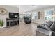 Bright living room featuring modern fireplace, light wood flooring, and ample natural light at 10308 Pineneedles Dr, New Port Richey, FL 34654