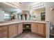 Bright bathroom featuring dual sinks, vanity, large mirrors, and a connecting door to the adjacent bedroom at 11545 Weaver Park Ct, Trinity, FL 34655