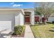 Inviting front entryway with a vibrant red front door, lush landscaping, and a well-maintained walkway at 11545 Weaver Park Ct, Trinity, FL 34655