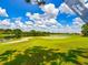 View of lush green golf course with lake and trees under blue sky at 11545 Weaver Park Ct, Trinity, FL 34655