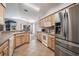 Well-lit kitchen with wooden cabinets, stainless steel appliances, and views to the dining and living areas at 11545 Weaver Park Ct, Trinity, FL 34655