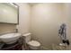 Small powder room featuring a pedestal sink, toilet, large mirror, and a dark wood vanity at 11739 Bayonet Ln # B, New Port Richey, FL 34654