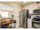 A kitchen featuring stainless steel appliances, tile countertops, and light wood cabinets at 11739 Bayonet Ln # B, New Port Richey, FL 34654