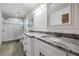 Bathroom with double sinks, granite countertops, and a glass-enclosed shower at 12215 Snead Pl, Tampa, FL 33624