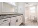 Modern bathroom with a granite vanity top, white cabinets and framed mirror with a tiled shower and tub at 12215 Snead Pl, Tampa, FL 33624
