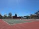 Well-maintained tennis courts with green and red surfaces, nets, and lighting for daytime and nighttime play at 12421 Dearborn Dr # D, Hudson, FL 34667