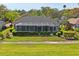 Backyard featuring a screened-in porch and beautiful mature landscaping at 12446 Quail Ridge Dr, Spring Hill, FL 34610
