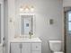 Well-lit bathroom featuring a modern vanity, toilet, and partially visible glass-enclosed shower at 12446 Quail Ridge Dr, Spring Hill, FL 34610