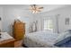 Cozy bedroom featuring wood floors, ceiling fan, and a comfortable bed with blue patterned bedding at 12446 Quail Ridge Dr, Spring Hill, FL 34610