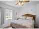Comfortable bedroom with wood floors, ceiling fan and comfortable bed with blue patterned bedding at 12446 Quail Ridge Dr, Spring Hill, FL 34610