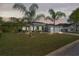 Well-maintained single-story home with lush lawn, palm trees, and a two-car garage under a twilight sky at 12446 Quail Ridge Dr, Spring Hill, FL 34610