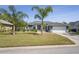 Beautiful single-story home with a well-kept lawn, palm trees, and a two-car garage at 12446 Quail Ridge Dr, Spring Hill, FL 34610