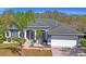 Single-Gathering home featuring mature landscaping, well-kept lawn, and two-car garage at 12446 Quail Ridge Dr, Spring Hill, FL 34610