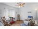 Cozy living room with a rocking chair, recliner, and natural light from the window with curtains at 12446 Quail Ridge Dr, Spring Hill, FL 34610
