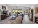 Spacious living room with tile flooring, ceiling fan, and sliding glass doors to the screened patio at 12446 Quail Ridge Dr, Spring Hill, FL 34610