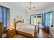 Cozy main bedroom with ceiling fan, wood floors, and natural light from sliding glass doors at 12446 Quail Ridge Dr, Spring Hill, FL 34610