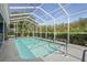 Clear view of the pool and surrounding area with well-manicured landscaping and a screened enclosure at 12446 Quail Ridge Dr, Spring Hill, FL 34610