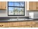 Bright kitchen features a stainless steel sink, black countertops, and wood cabinets at 1267 Meredith Dr, Spring Hill, FL 34608