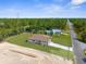 High aerial shot of a house with a green lawn and long driveway close to a dense forest at 16043 Penn State Rd, Weeki Wachee, FL 34614