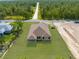 A high aerial view of a house with a new roof and green lawn amidst a lush forested area at 16043 Penn State Rd, Weeki Wachee, FL 34614