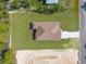 Overhead aerial view of a house featuring a driveway and pristine lawn, bordered by a construction site at 16043 Penn State Rd, Weeki Wachee, FL 34614