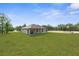 Spacious backyard showcasing lush lawn and the rear elevation of the single-story home at 16043 Penn State Rd, Weeki Wachee, FL 34614