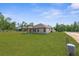 Spacious backyard with lush green grass and a covered patio, perfect for outdoor living at 16043 Penn State Rd, Weeki Wachee, FL 34614