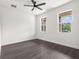 Bright bedroom with two windows, ceiling fan, and wood-look floors at 16043 Penn State Rd, Weeki Wachee, FL 34614