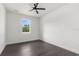 A cozy bedroom is brightened by a large window and modern ceiling fan at 16043 Penn State Rd, Weeki Wachee, FL 34614